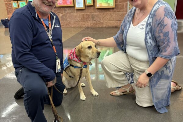 One of the Dell Children's Medical Center Chaplains and conductor/Symphonic Choir alto Courtney Aguilar are joined by Junie the therapy dog.
